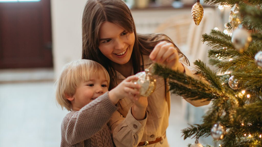 A mother and son decorating a christmas tree