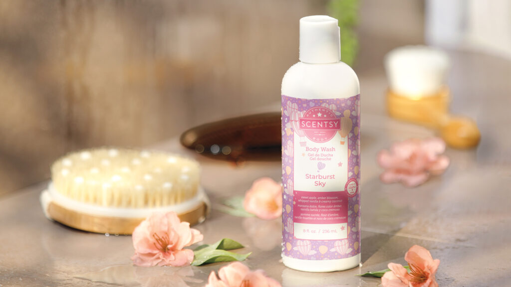 Scentsy body wash scented in starburst sky sitting beside flower petals and dry brushes