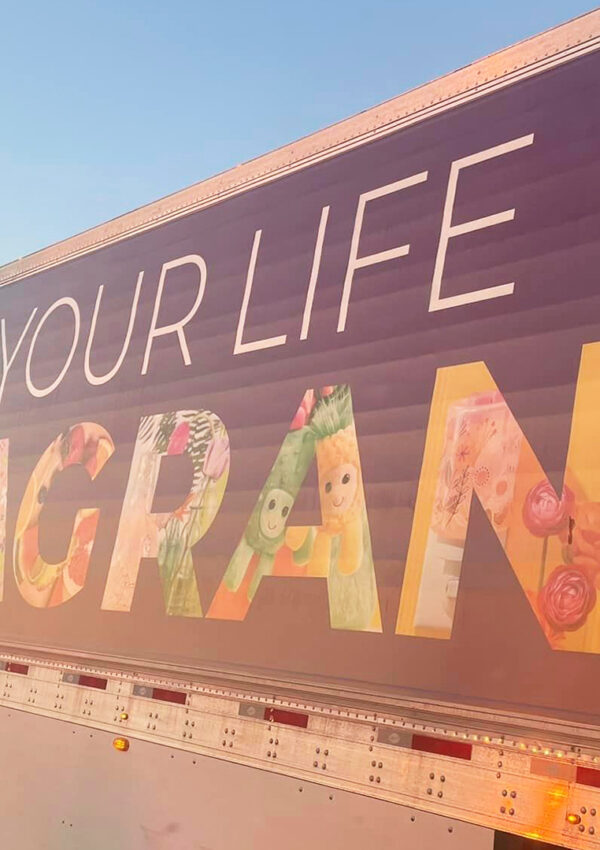 Scentsy’s colorful trailer semi truck cruising on the highway across America