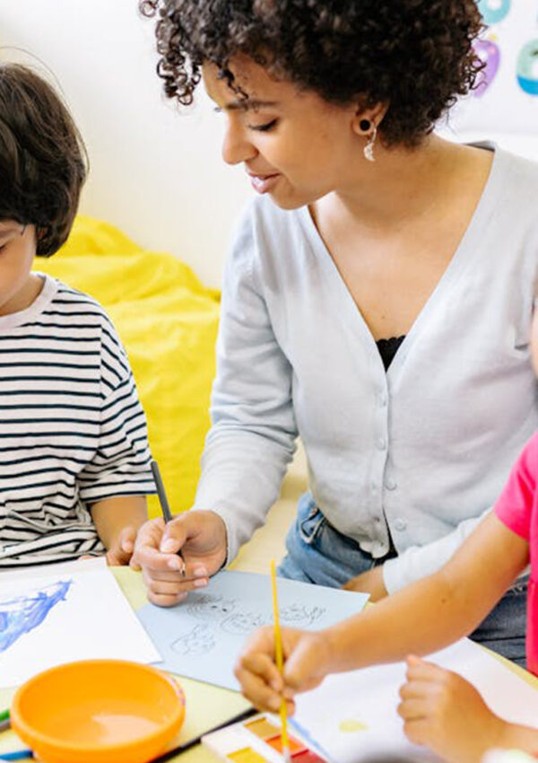 A teacher and her young students painting pictures