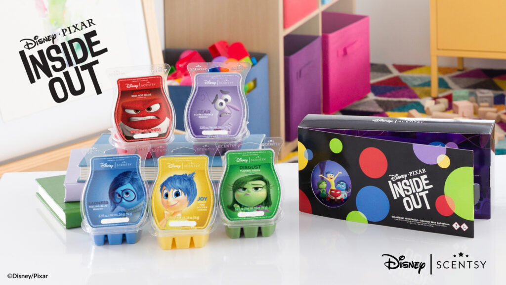 A photograph of the Disney's Inside Out Scentsy Wax Bars collection displayed on a white table with a craft room in the background.