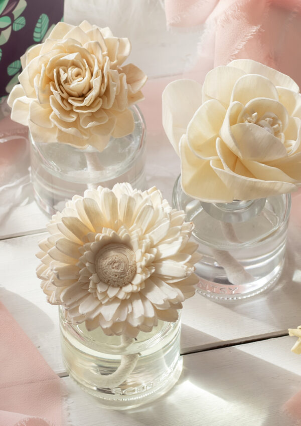 Several different Scentsy Sola Wood Fragrance Flowers decorate a pink and white themed wedding table.