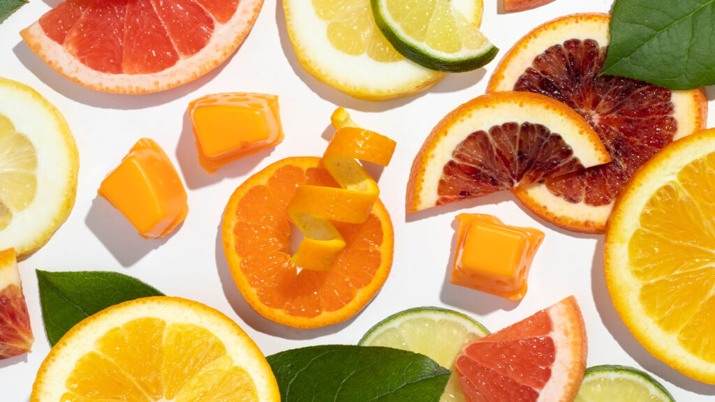 Scentsy wax cubes displayed around many slices of citrus fruits to depict the fragrance notes of the wax bar.