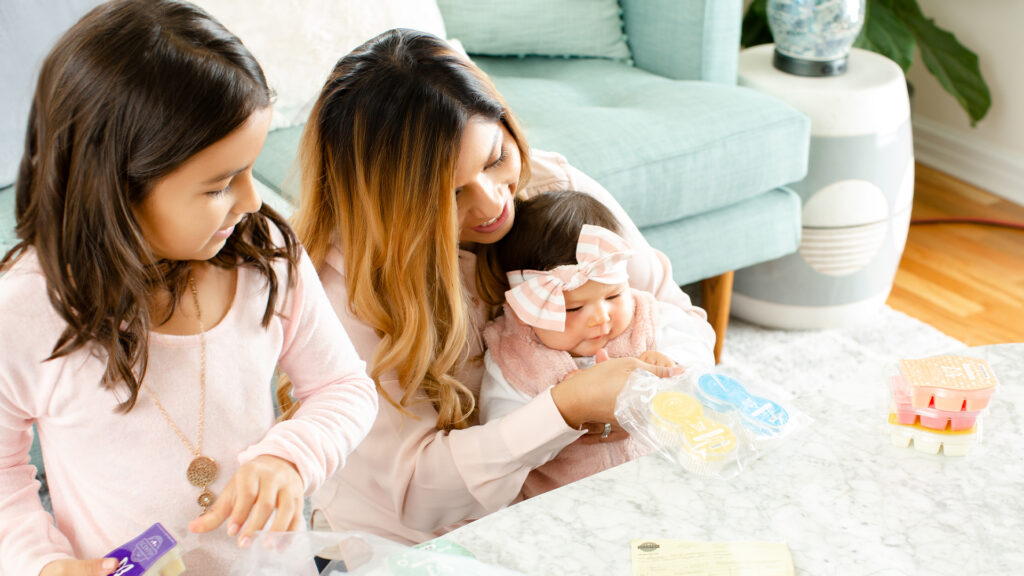 A mother and her two children play with Scentsy pods and wax bars.