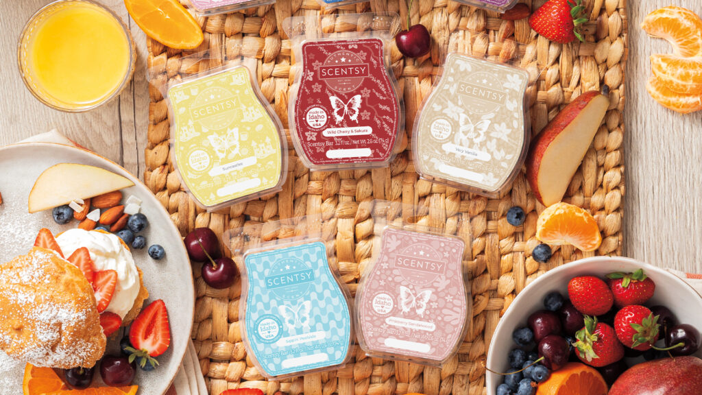 An staged image of five Scentsy wax bars surrounded by citrus fruits and breakfast foods to indicate the wax bar's fragrance notes.