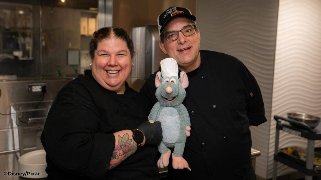 Two chefs from Scentsy Home Office holding the Disney Ratatouille Scentsy Buddy