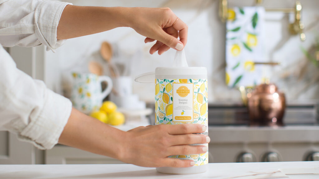 a hand pulling a swipe from a container of Squeeze the Day Scentsy Swipes