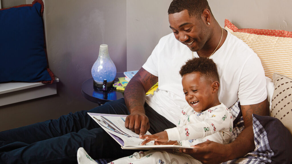 A father reads a book to their child.