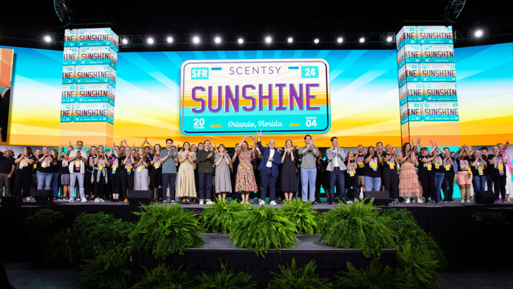 The Scenstsy Scentsy Family Reunion team gathers and cheers together on the SFR main stage!