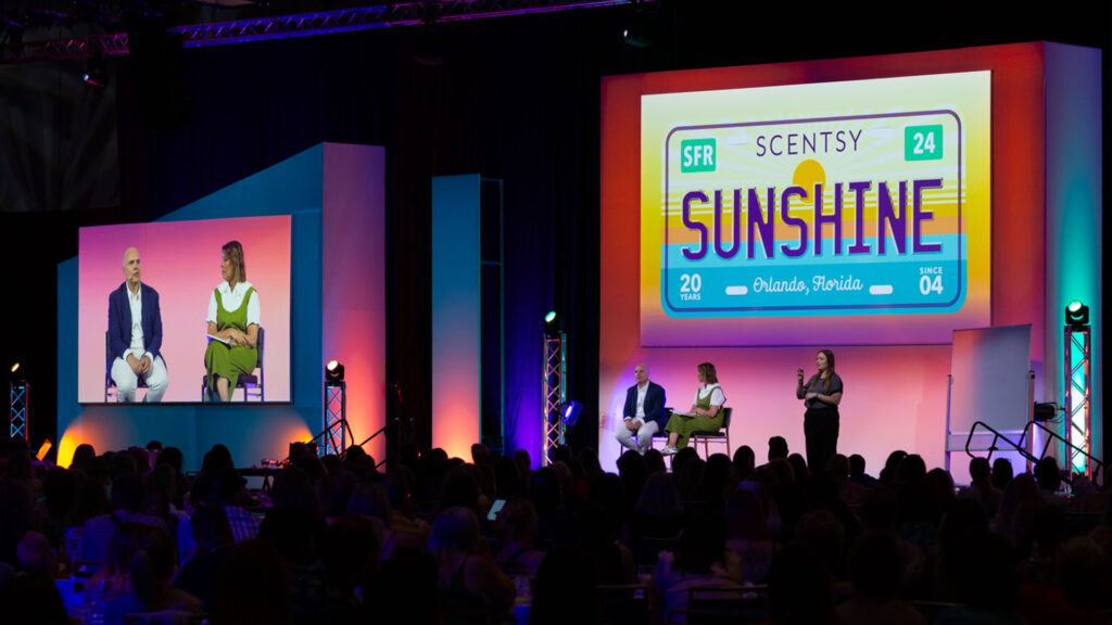 Heidi and Orville Thompson speak on stage at the Scentsy Family Reunion conference. 