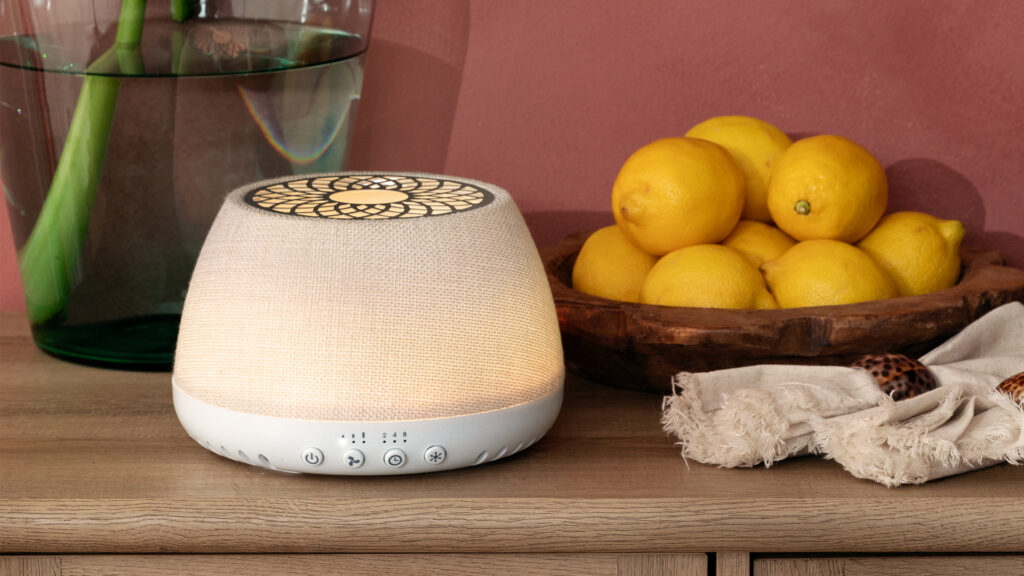 A Scentsy Air displayed on a table next to a basket of lemons and a towel.