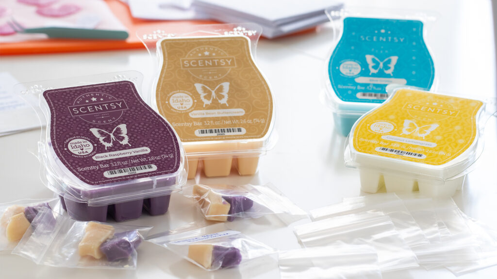 Scentsy wax bar clamshells with cubes cut into pieces and placed into small bags beside them.