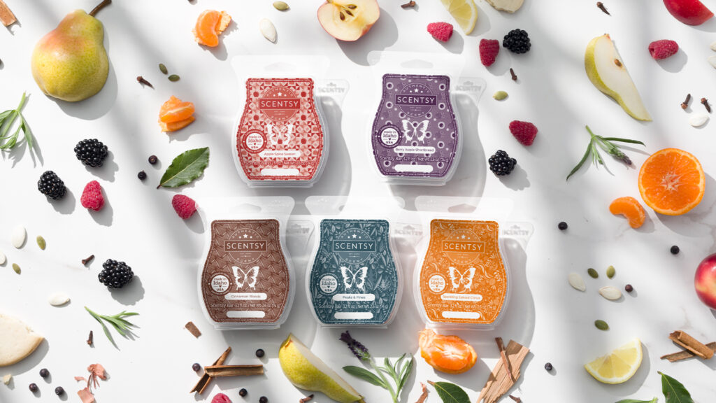 Scentsy wax bars from Scentsy's 2024 Harvest Collection photographed amidst fruits and herbs indicating the wax bar's fragrance notes.