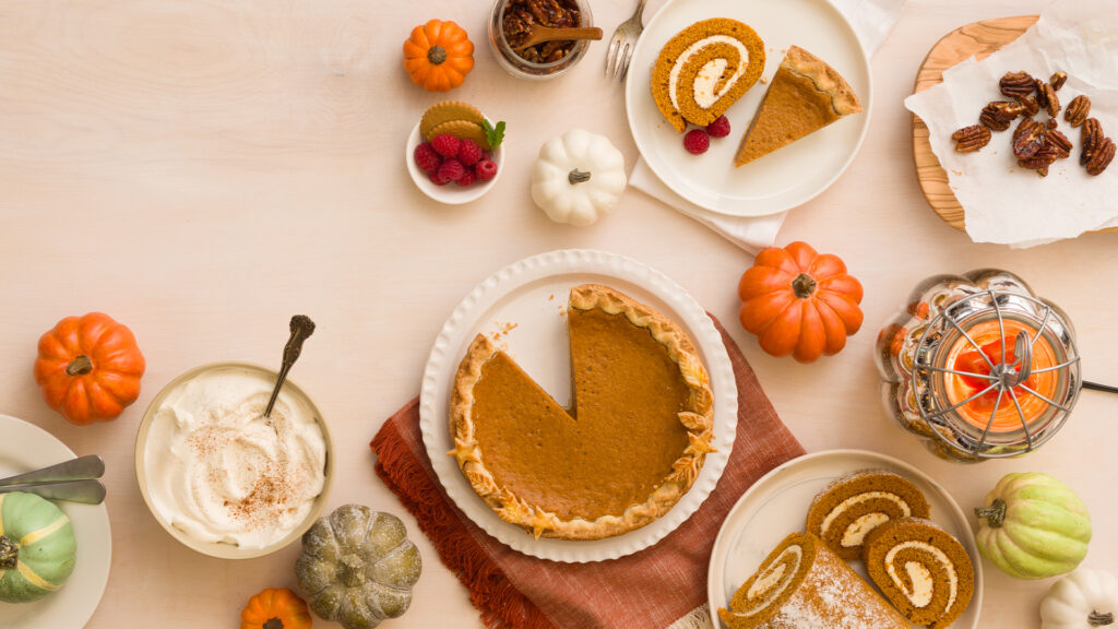 A variety of fall-themed baked goods arrayed on a table with a Scentsy Pumpkin Sparkle Warmer.