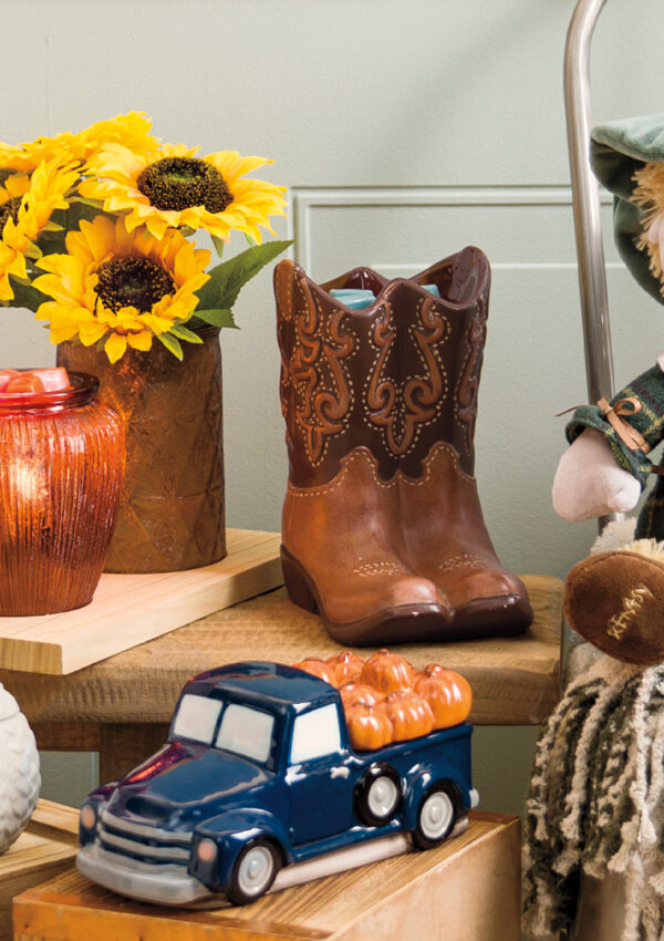 A photo of Scentsy's fall lineup of warmers and buddies arranged around sunflowers, pumpkins, and other seasonal decor.