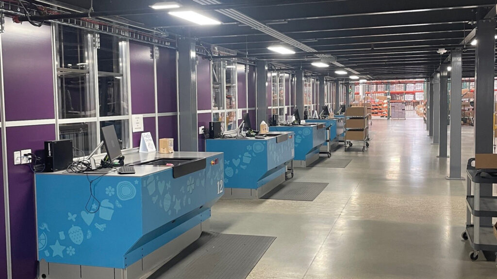 A row of sorting and packaging stations in the Scentsy packing and shipping facility.