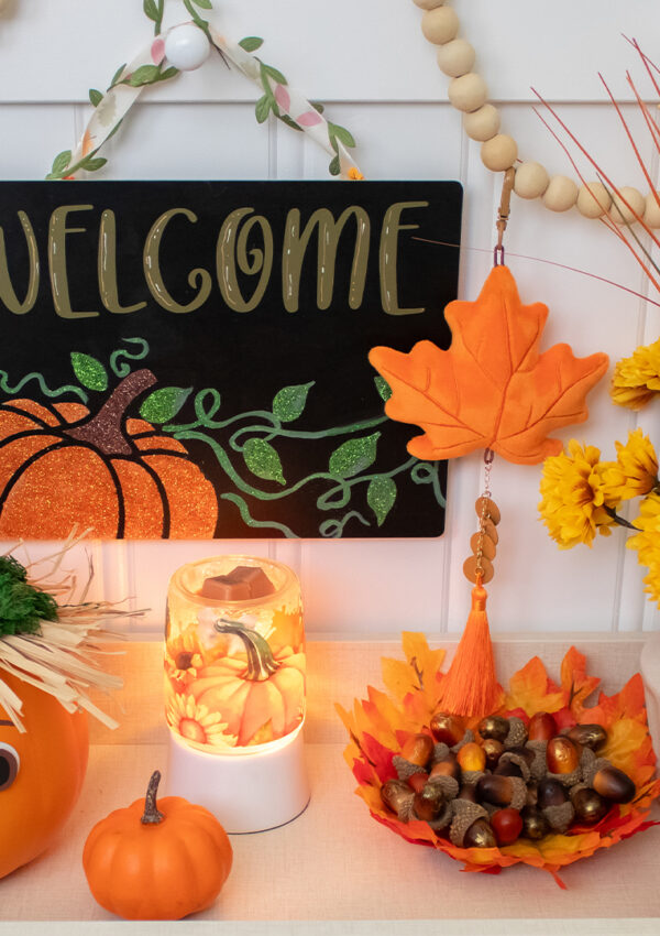 A table filled with flowers, pumpkins and similarly themed harvest and halloween decorations.