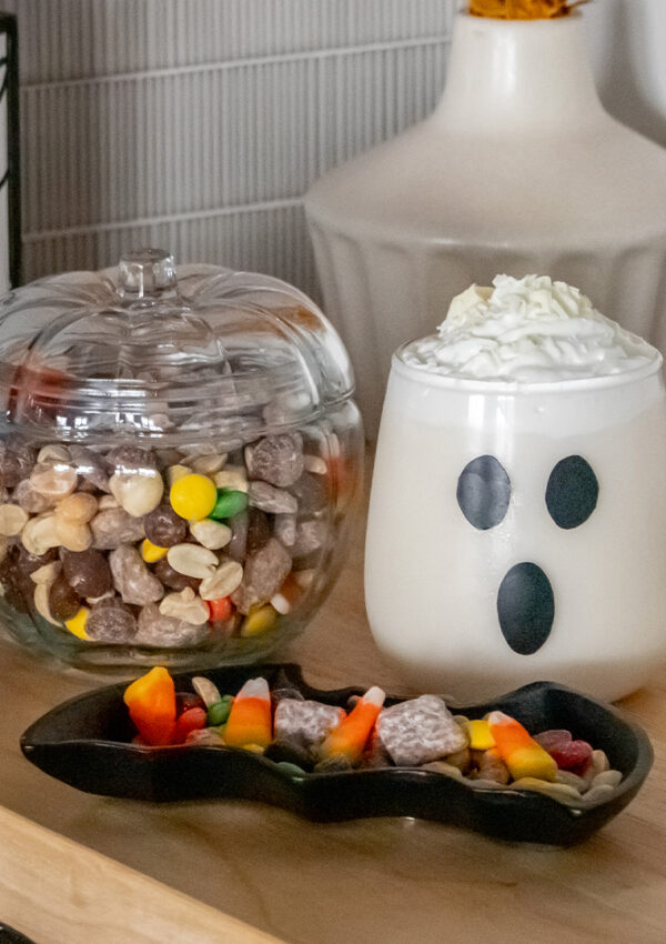 A table decorated and with Halloween themed candy, snacks, and decorations.