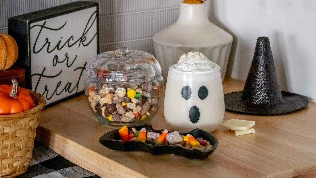 A table decorated and with Halloween themed candy, snacks, and decorations.