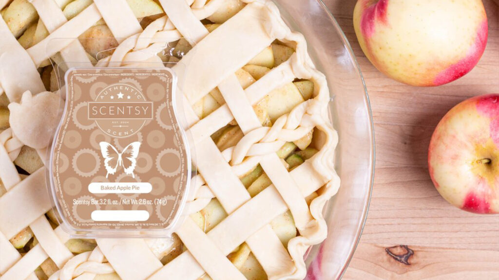 Scentsy Baked Apple Pie Wax Bar sitting atop apple pie crust and several apples.