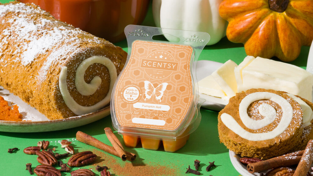 Scentsy Pumpkin Roll wax bar surrounded by cinnamon sticks, nuts, and a freshly baked pumpkin roll.