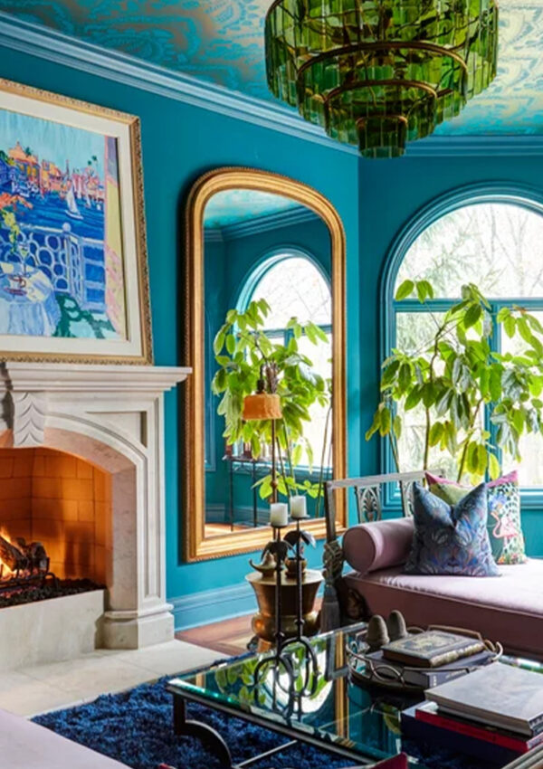 A livingroom decorated with bold blues and green colors and art deco styling.