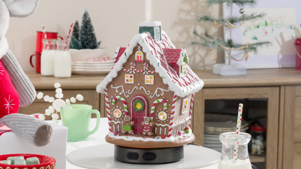 Scentsy's Sugar Chalet Diffuser sitting on a table full of winter decorations