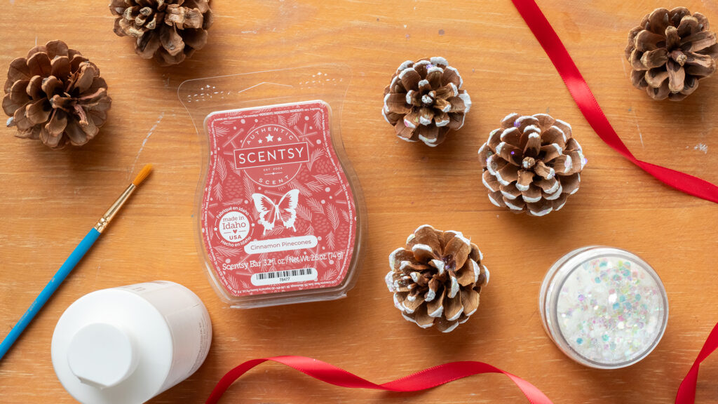 The Scentsy Cinnamon Pinecones Wax Bar next to DIY painted pinecone ornaments.