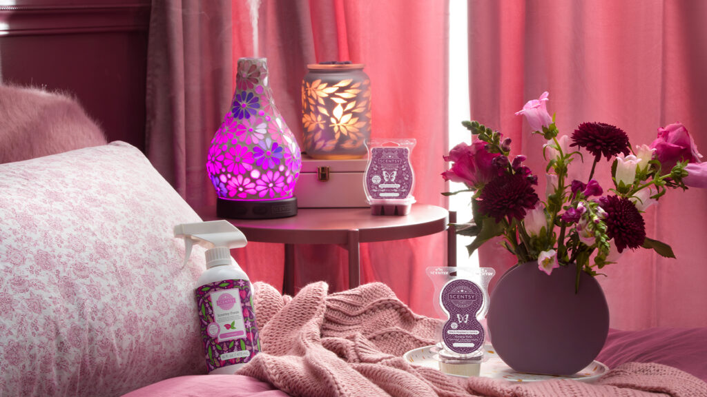 Scentsy warmers, diffusers, laundry, and pods products arrayed in a bedroom.