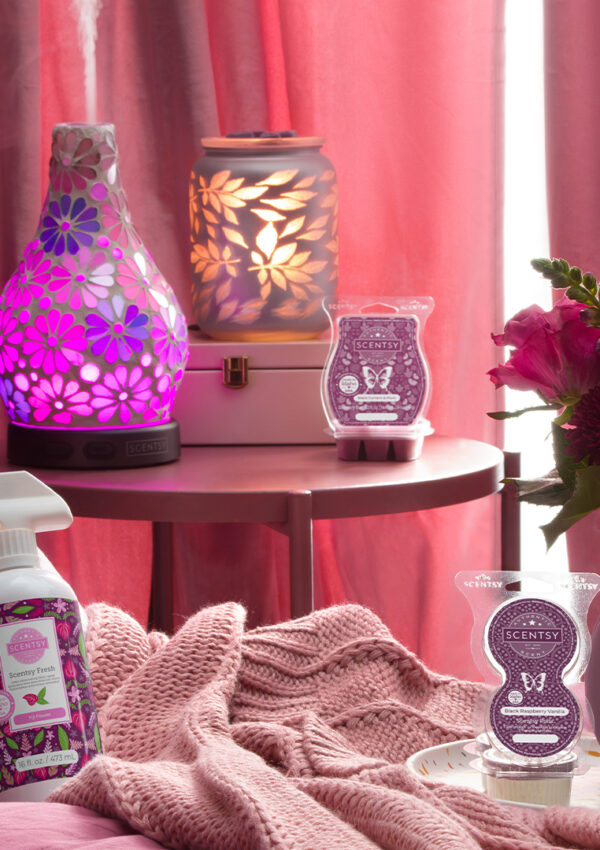 Scentsy warmers, diffusers, laundry, and pods products arrayed in a bedroom.