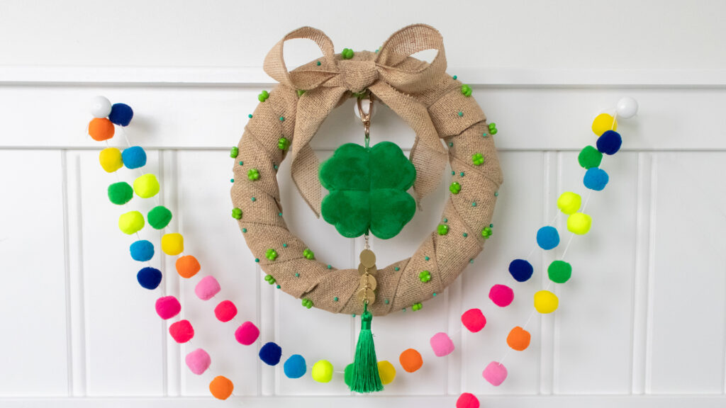 A hand-made St Patrick's Day wreath with Scentsy Four Leaf Clover Charm Clip hangs on a mantle.