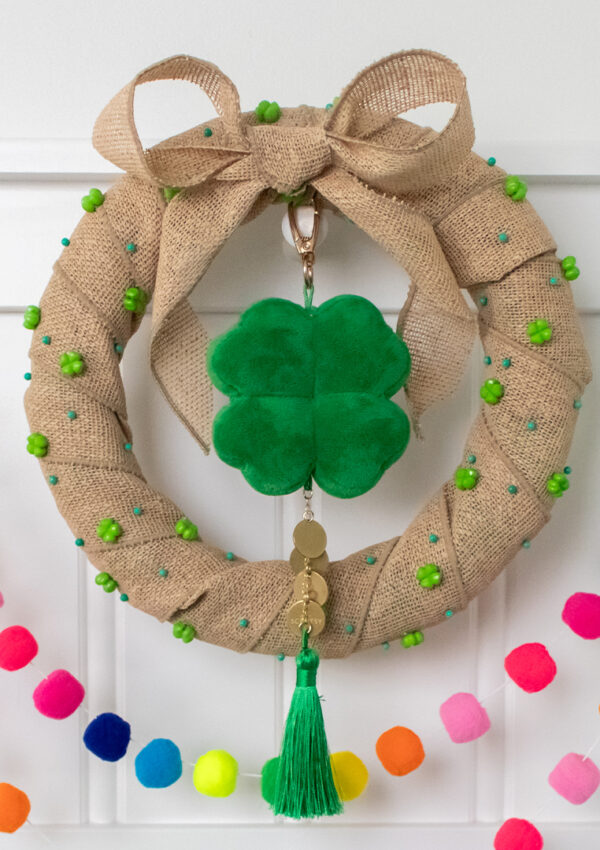 A hand-made St Patrick's Day wreath with Scentsy Four Leaf Clover Charm Clip hangs on a mantle.