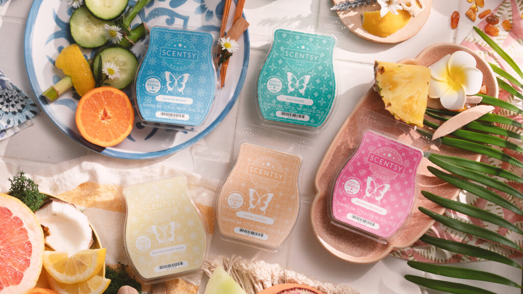 The Scentsy Destinations collection wax bars lay on a table amongst mediterranean spices, fruit slices, palm fronds, and mosaic patterned dishes.