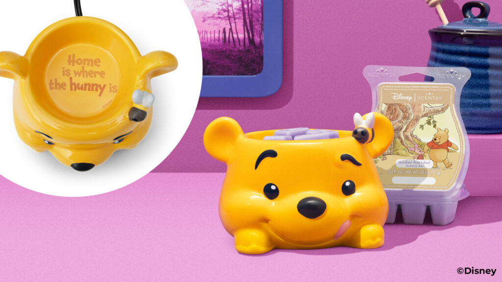The Disney Winnie the Pooh: Warm Fuzzies - Scentsy Warmer with the Hundred Acre Wood Scentsy Bar beside it, on a purple table with a purple background and a blue ceramic honey pot beside it.