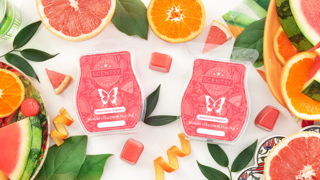 Two of Scentsy's Watermelon Tangerine Wax Bars in red labled clam shells sit on a white background surrounded by red wax cubes, tangerines, and watermelon fruit wedges.