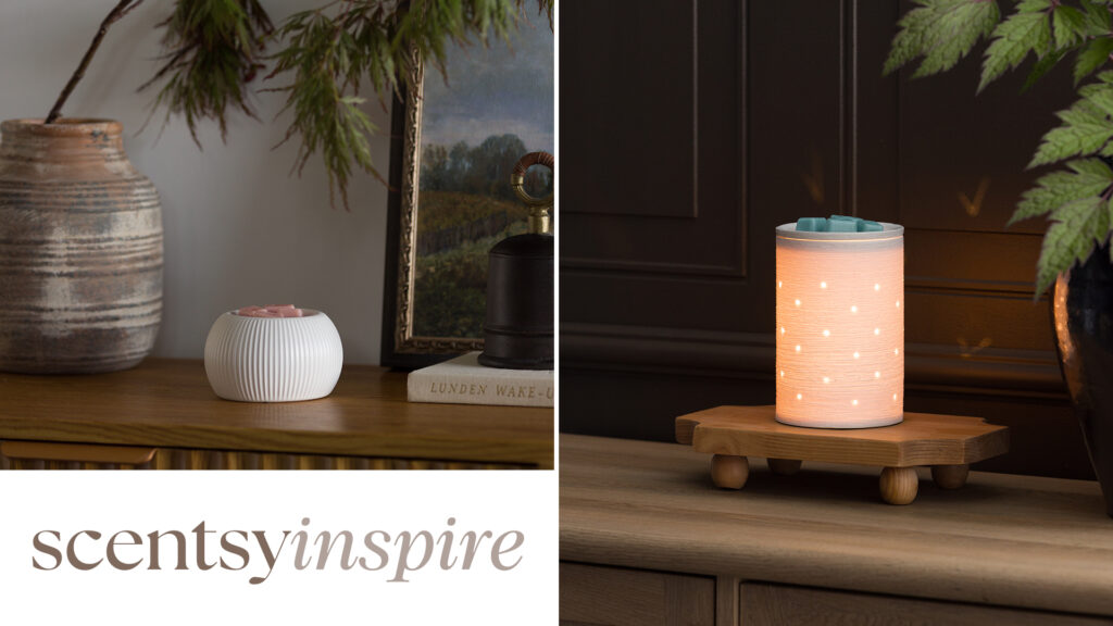 Two elegant, ceramic Scentsy Warmers from the Scentsy Inspire product line are depicted on wooden credenzas and decorated with neutral toned vases, picture frames, and green foliage.