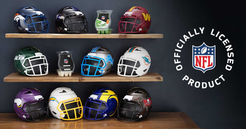 Scentsy NFL helmet warmers, each depicting one of ten professional NFL football teams, are displayed on wood shelving beside the official NFL logo.