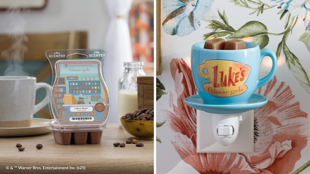 The Gilmore Girls Luke's Diner Wax Bar clamshell containing brown wax melts sits on a table beside a cup of steaming coffee and some spilled coffee beans. Beside it Luke's Coffee Mug Mini Warmer, shaped to look like a blue coffee cup with the Luke's Diner logo from the Gilmore Girls TV show, is plugged into a wall covered in floral wallpaper.