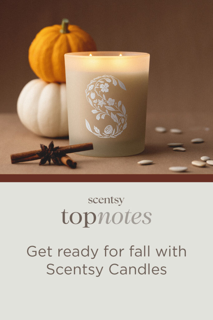 A beige colored Scentsy Candle, with a white, monogrammed "S" pattern on its frosted glass vessel, sits on a light brown table beside stacked orange and white pumpkins, pumpkin seeds, and cinnamon sticks. The words "Get ready for fall with Scentsy Candles" sit below the Scentsy Top Notes Blog logo. 