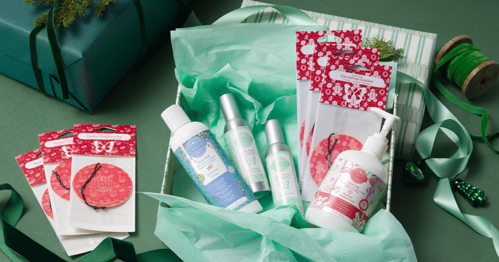 A Scentsy Gift Set Christmas gift filled with Scentsy Body Wash, Room Sprays, Hand Soap, and Scent Circles. The gift is packed with green tissue paper and the box is wrapped with green and white striped wrapping paper and green ribbons. 