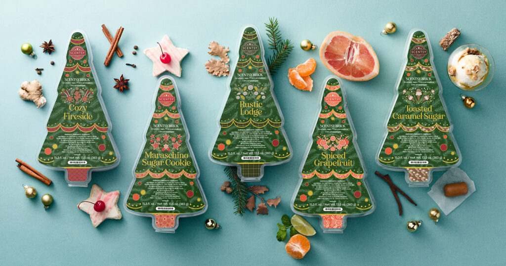 Scentsy Holiday Wax Bricks shaped like Christmas trees surrounded by cinnamon sticks, Christmas ornaments, orange slices, caramel, ginger root, and Christmas cookies.