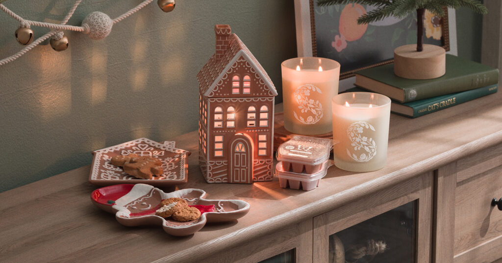 The Scentsy Gingerhaus Warmer sits next to two cookie-filled Gingerbread Plates, wax melts, and candles from the Gingerbread Holiday Special.